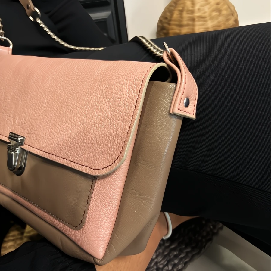Sac bandoulière en cuir de chèvre taupe et rose avec un fermoir en metal style cartable Sac bandoulière en cuir de chèvre taupe et rose avec un fermoir en metal style cartable