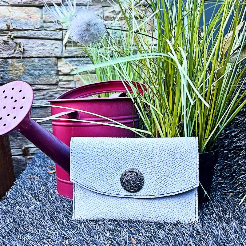 Pochette passeport en cuir de veau blanc effet lézard avec un fermoir rosas en metal argenté noirci Pochette passeport en cuir de veau blanc effet lézard avec un fermoir rosas en metal argenté noirci